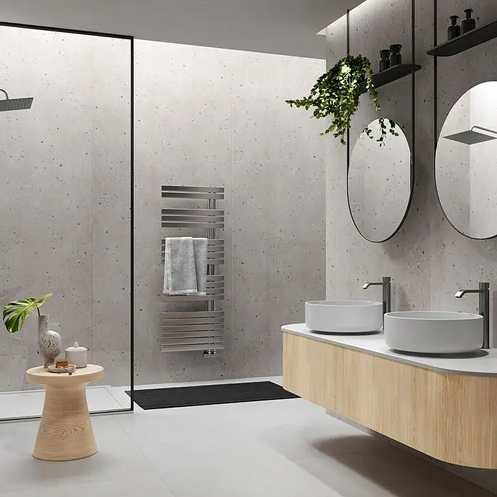Wetwall Wandpaneel Elite - 16 x 242 cm, Pewter Terrazzo, Abgerundete Kante - Ein modernes Badezimmer mit beheiztem Handtuchhalter, Waschtischen, Spiegeln und Pflanzen sorgt für eine stilvolle und funktionale Atmosphäre.