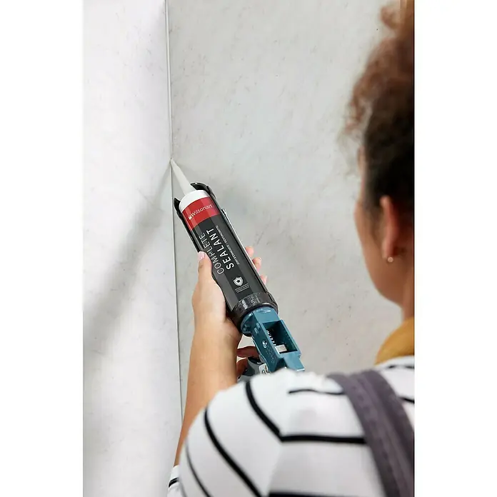 Dichtmasse Wilsonart Complete Sealant - 290 ml, Mushroom - Eine Person trägt Wilsonart Fugenmasse auf eine Wand auf, wobei der Fokus auf dem Produkt und seiner Anwendung liegt.