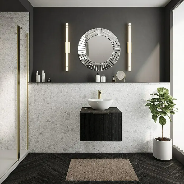 Wetwall Wandpaneel Elite - 16 x 242 cm, Terrazzo White, Abgerundete Kante - Elegantes Badezimmer mit rundem Spiegel und schwebendem Waschtisch in Schwarz, ergänzt durch stilvolle Beleuchtung und eine Zimmerpflanze.