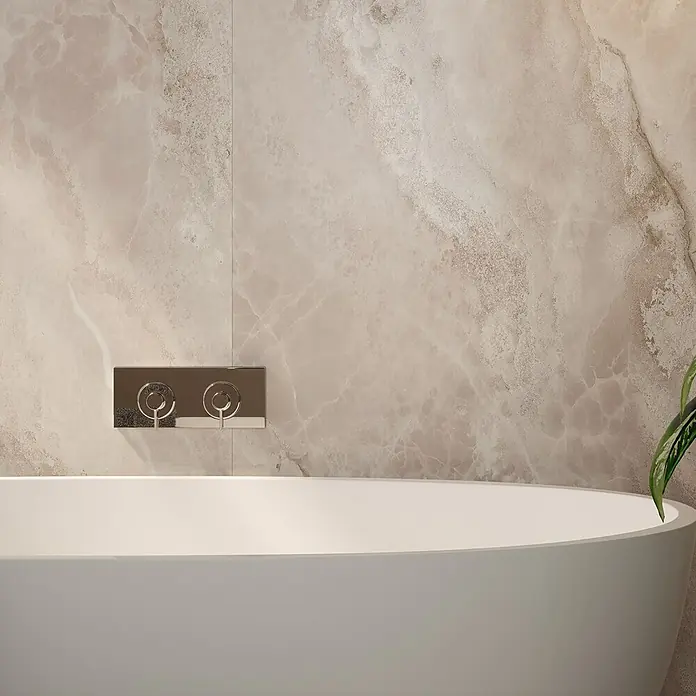 Wetwall Wandpaneel Elite - 16 x 242 cm, Onyx Grey, Abgerundete Kante - Detailaufnahme einer Badewanne mit Armatur vor einer beige-marmorierten Wand.