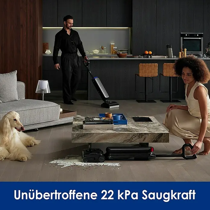 Tineco Akku-Nass-Trockensauger FLOOR ONE S9 Artist Premium - Saugkraft: 22.000 Pa, Akkulaufzeit: 50 min, Wassertankvolumen: 1 l - Ein Mann saugt mit einem Staubsauger Flüssigkeit auf, während eine Frau zusieht.