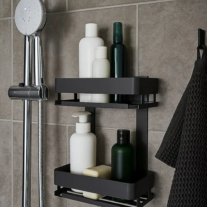 Cesta de baño doble Balance - 12,5 x 25 x 32,5 cm, Aluminio, Gun grey - Estante de baño gris de dos niveles lleno de artículos de aseo blancos y verdes, junto a una ducha y una toalla.