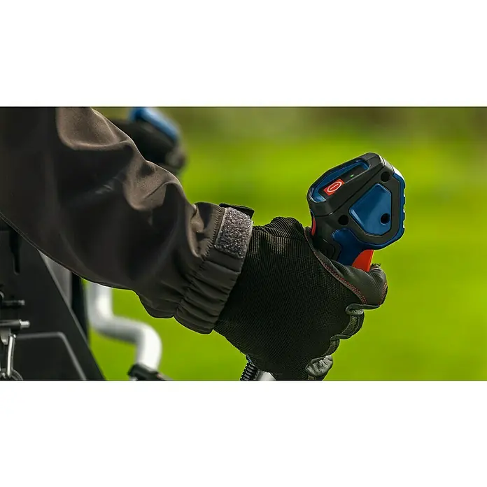 Bosch Professional AMPShare 18V Akku-Freischneider GFR18V-25 BH - 18 V, Schnittbreite Faden: 40 cm, Schnittbreite Messer: 25 cm - Nahaufnahme der Hand in einem Handschuh, die einen Bosch-Wärmedetektor mit rotem und blauem Gehäuse hält, vor einem grünen Hintergrund.
