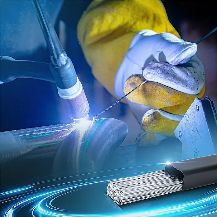 STAHLWERK WIG-Schweißstab Schweißstäbe ER4043Si5 Aluminium hochlegiert / Ø 1,6 mm x 500 mm 2 kg - Durchmesser: 1,6 mm - Nahaufnahme eines Schweißers mit Schweißdraht, der ein Metallstück schweißt. Im Vordergrund liegt ein Bündel von Schweißdrähten.