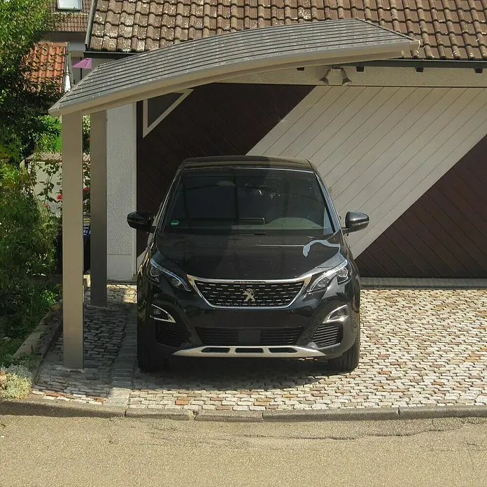 Ximax Carport PF60 - Außenmaß inkl. Dachüberstand (B x T): 3,01 x 5,56 m, Einzelcarport, Edelstahl-Look - Hier parkt ein schwarzer Peugeot SUV unter einem Carport mit braun-weißen Garagentor im Hintergrund.