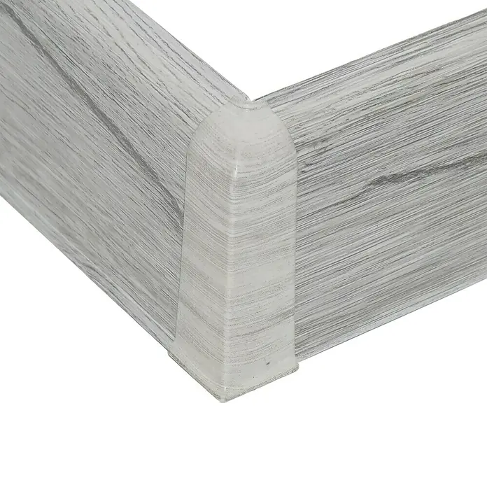 Außenecke Vigo - Scandinavian Eiche, 2 Stk. - Eckdetail einer Sockelleiste in Holzoptik. Das Profil ist hellgrau und passt ideal zu modernen Fußböden. Perfekt für einen sauberen Wandabschluss.