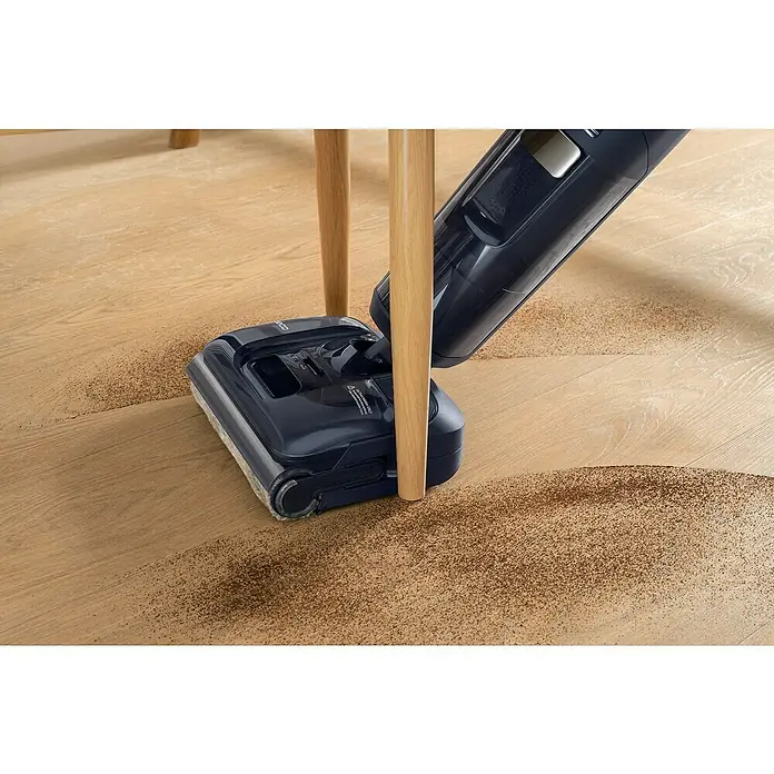 Tineco Akku-Nass-Trockensauger FLOOR ONE S7 Strech - Saugkraft: 21.000 Pa, Akkulaufzeit: 50 min, Wassertankvolumen: 1 l - Der DEEBOT Akku-Staubsauger reinigt mühelos Schmutz auf einem Holzboden unter einem Tisch und sorgt für ein sauberes Zuhause.