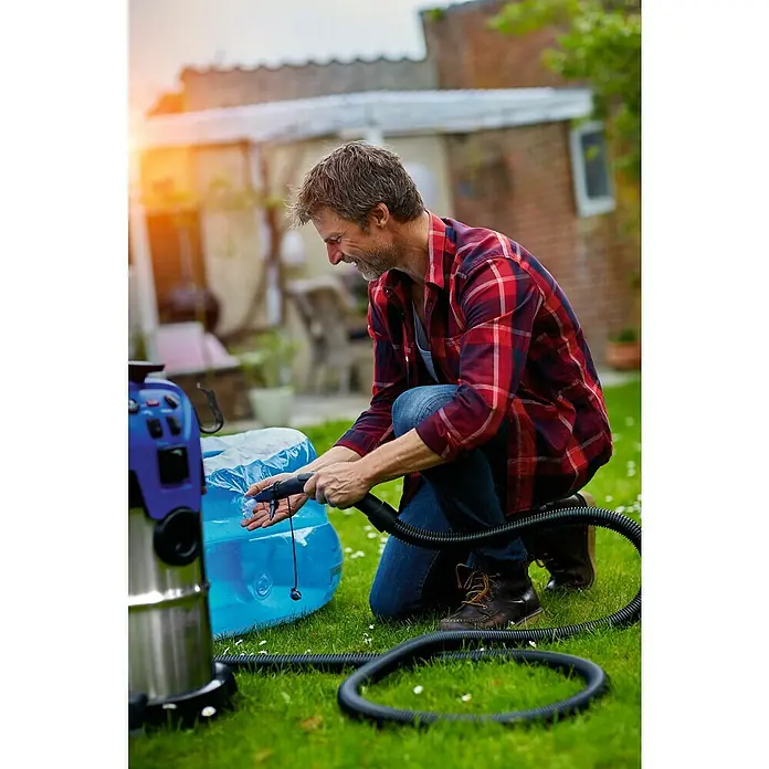 Nilfisk Elektro-Nass- & Trockensauger Multi II 30 T EU - 1.400 W, Behältervolumen: 30 l, Halbautomatisch - Ein Mann befüllt einen blauen aufblasbaren Pool mit einer blauen Nass- und Trockensauger auf einem grünen Rasen.