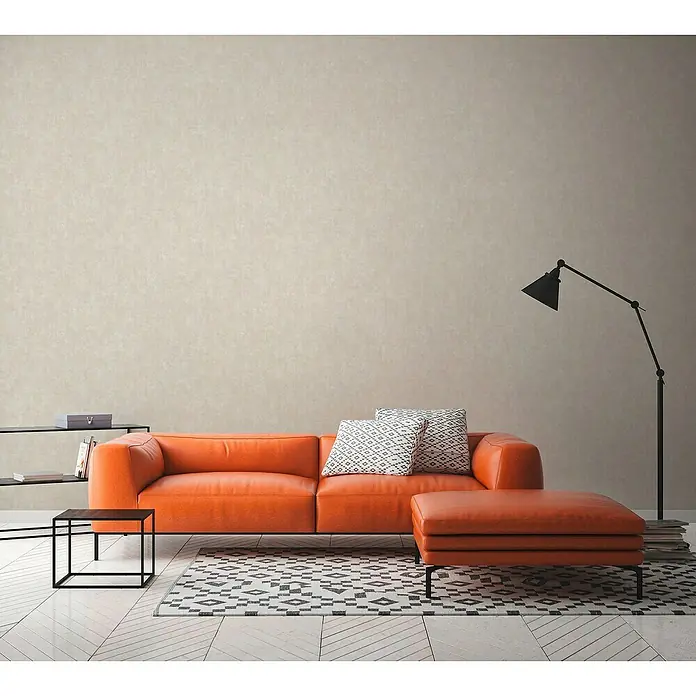 A.S. Création Hygge 3 Vliestapete - Mittelbeige, Uni, 10,05 x 0,53 m - Wohnzimmer mit einem stilvollen, orangefarbenen Ledersofa, das einen Hauch von Wärme und Komfort in den Raum bringt.