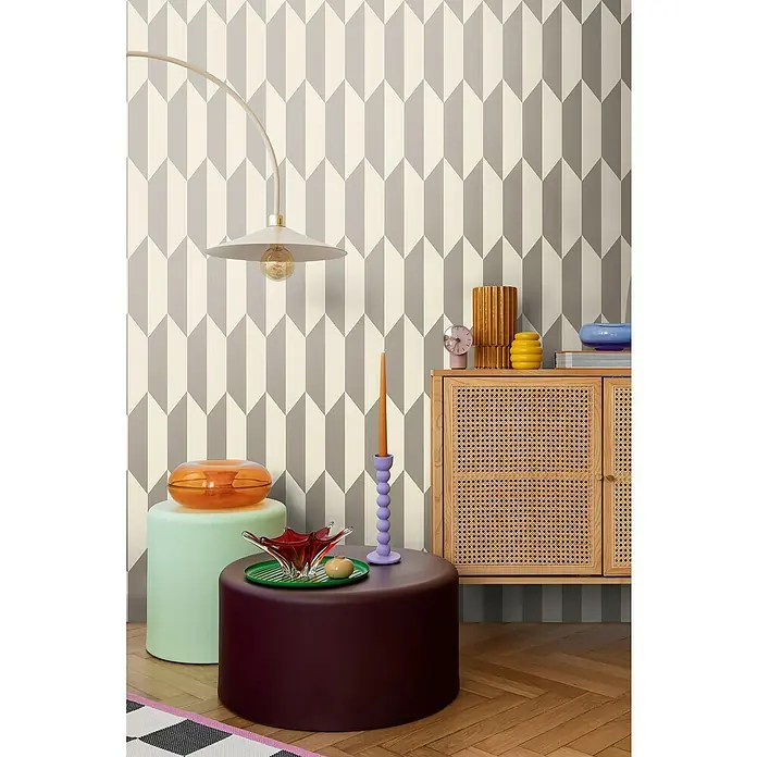 A.S. Création Cosmoliving by Cosmopolitan Vliestapete 3D-Grafik - Creme-Metallic, Grafisch, 10,05 x 0,53 m - Raumansicht mit modernen Möbeln vor einer Wand mit einem geometrischen Pfeilmuster in Grau und Beige.
