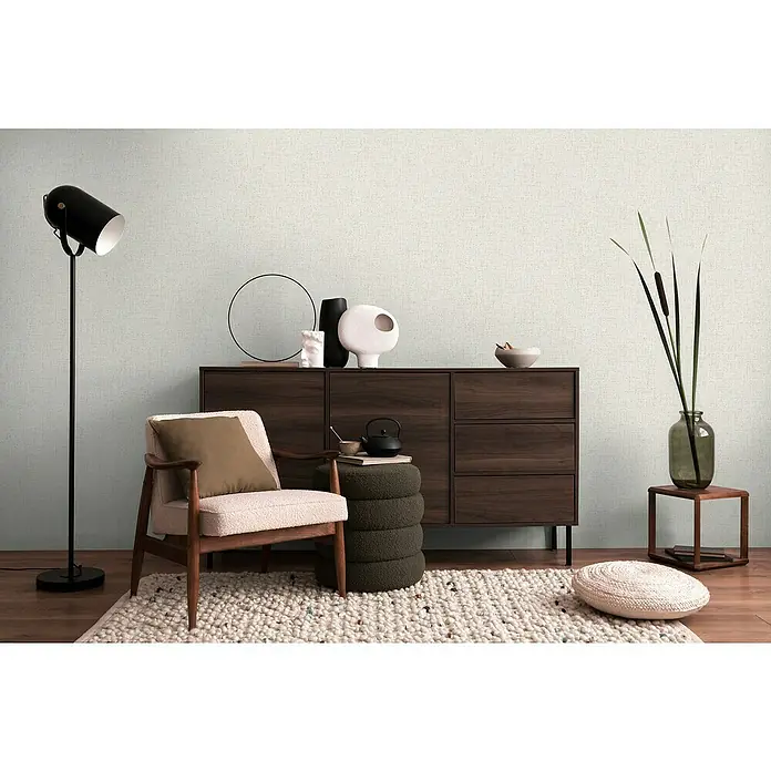 A.S. Création Cosmoliving by Cosmopolitan Vliestapete - Hellgrau, Uni, 10,05 x 0,53 m - Ein stilvolles Wohnzimmer mit einem dunklen Holzschrank, einem Sessel und einer Stehlampe, die eine gemütliche und elegante Atmosphäre schafft.