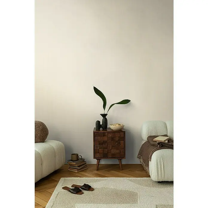 A.S. Création Cosmoliving by Cosmopolitan Vliestapete - Hellcreme, Uni, 10,05 x 0,53 m - Stilvolle Inneneinrichtung mit einem dunklen Holzschrank, einer minimalistischen Vase und einer beigen Couch. Gemütliches Ambiente mit Teppich und Dekoration.