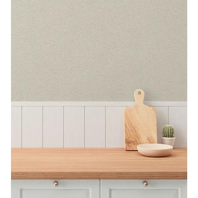A.S. Création Hygge 3 Vliestapete - Grau-Beige, Uni, 10,05 x 0,53 m - Nahaufnahme einer Arbeitsplatte mit Schneidebrett, Schale und Kaktus vor einer strukturierten Wand und weißen Paneelen.