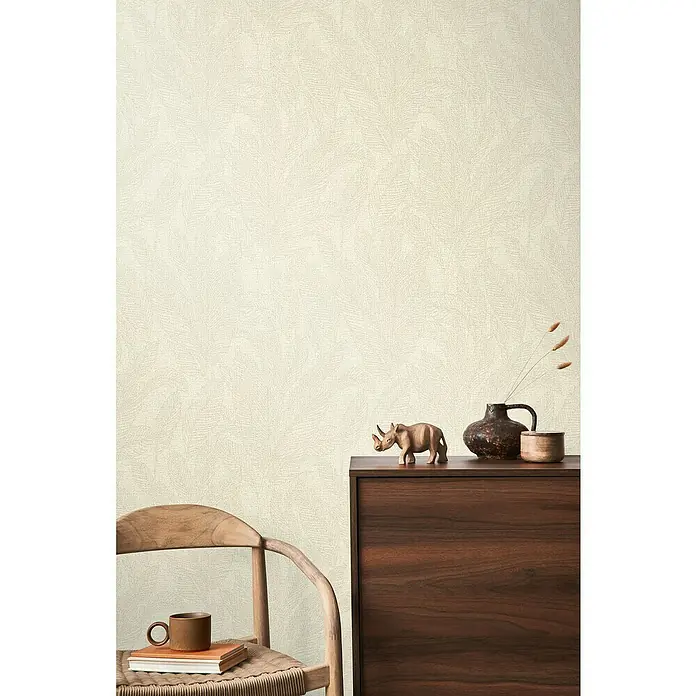 A.S. Création Cosmoliving by Cosmopolitan Vliestapete Blätter - Creme-Grau-Grün, Floral, 10,05 x 0,53 m - Einrichten mit Rhinozeros-Figur, Keramikvase und Tasse auf dem Tisch und Stuhl, die ein gemütliches und stilvolles Ambiente schaffen.