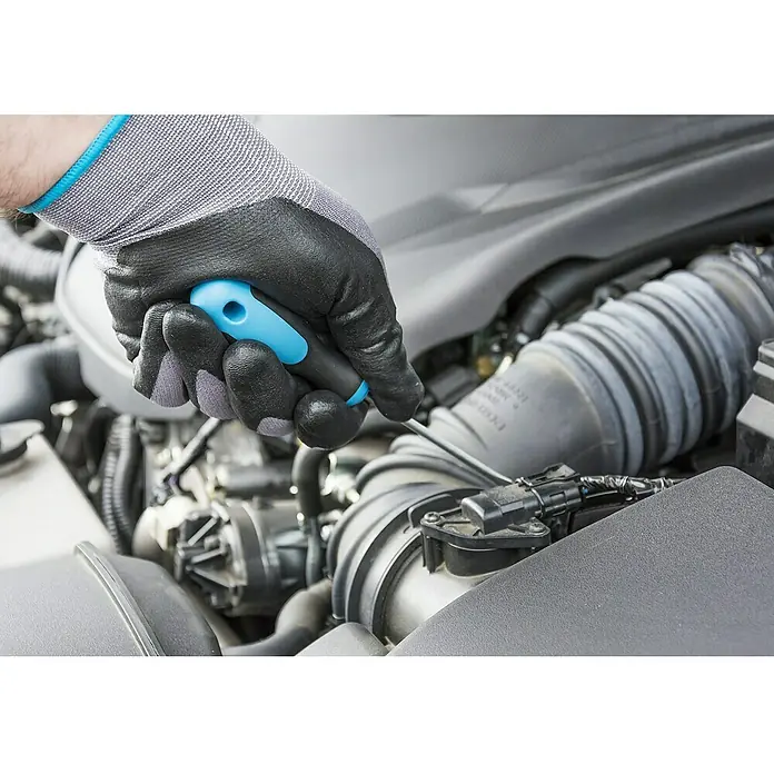 Hazet Schraubendreher-Set 810/6 - 6 -tlg. - Ein Mechaniker justiert mit einem Schraubendreher in einem Motorraum, wobei er einen Schutzhandschuh trägt.