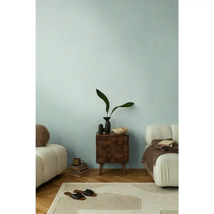 A.S. Création Cosmoliving by Cosmopolitan Vliestapete - Türkis meliert, Uni, 10,05 x 0,53 m - Stilvolles Interieur mit einem dunklen Holzschrank, einer Vase mit Pflanzen und bequemen Sitzmöbeln.