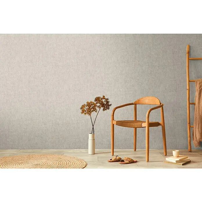 A.S. Création Cosmoliving by Cosmopolitan Vliestapete - Beigegrau, Uni, 10,05 x 0,53 m - Holzstuhl mit gewebter Sitzfläche, neben einem Dekoleiter und einer Vase mit Blumen. Wohnliches, helles Ambiente.