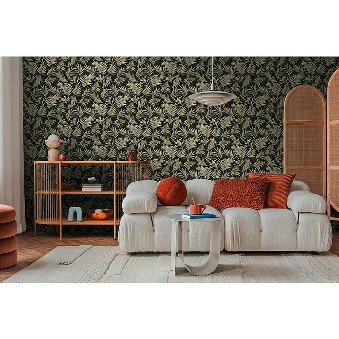 A.S. Création Cosmoliving by Cosmopolitan Vliestapete Ranken - Schwarz-Gold-Grün, Floral, 10,05 x 0,53 m - Wohnzimmer mit einem weißen Sofa, einem Couchtisch und einem Regal. Die Tapete hat ein tropisches Blattmuster.