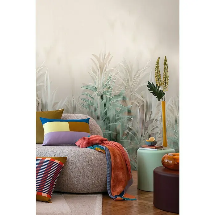 A.S. Création Cosmoliving by Cosmopolitan Fototapete Palmen - B x H: 159 x 280 cm, Vlies - Einrichtungsszene mit farbenfrohen Kissen und einer gestreiften Decke auf einem grauen Sessel vor einer Wand mit Pflanzenmotiv. Gelbe Vase.