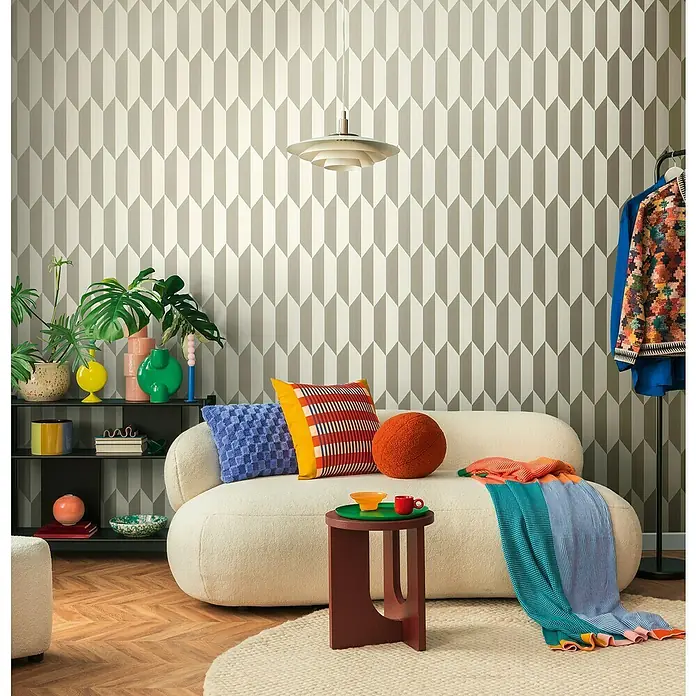 A.S. Création Cosmoliving by Cosmopolitan Vliestapete 3D-Grafik - Silber-Metallic-Braun, Grafisch, 10,05 x 0,53 m - Wohnzimmer mit weißem Sofa, farbenfrohen Kissen und einer gemusterten Tapete. Die Lampe hängt von der Decke.