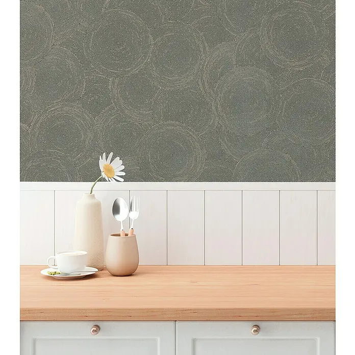 A.S. Création Hygge 3 Vliestapete Kreise - Grau-Braun, Grafisch, 10,05 x 0,53 m - Nahaufnahme eines Raumes mit einer strukturierten grauen Tapete, einer weißen Wandvertäfelung und einer hellen Holzplatte mit Geschirr und Dekorationen.