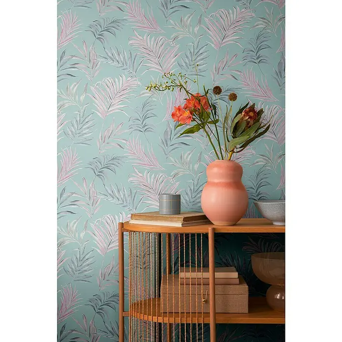A.S. Création Cosmoliving by Cosmopolitan Vliestapete Ranken - Blau-Rosa-Grau, Floral, 10,05 x 0,53 m - Nahaufnahme eines Bücherregals mit einer Blumenvase, Büchern und dekorativen Schachteln vor einer botanischen Tapete.