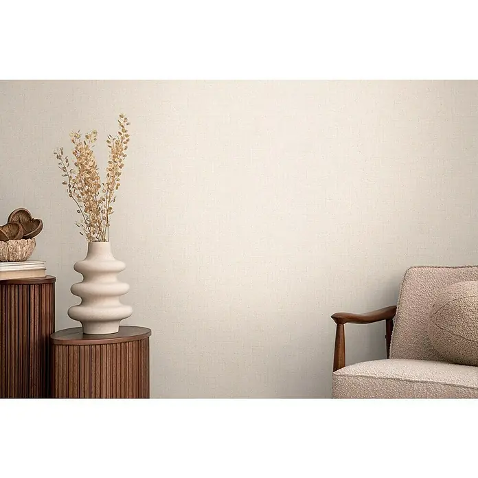 A.S. Création Cosmoliving by Cosmopolitan Vliestapete - Creme, Uni, 10,05 x 0,53 m - Nahaufnahme eines dekorierten Raumes mit einer Vase mit Blumen auf einem Holzschrank und einem rosa Sessel, der ein gemütliches Ambiente schafft.