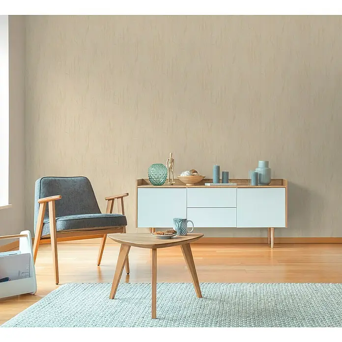 A.S. Création Hygge 3 Vliestapete Floral - Beige-Gelb, Floral, 10,05 x 0,53 m - Modernes Wohnzimmer mit hellblauem Teppich, grauem Sessel und weißem Sideboard. Dekorative Elemente auf dem Sideboard.