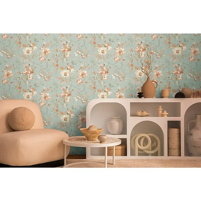 A.S. Création Cosmoliving by Cosmopolitan Vliestapete Blüten - Blau-Grau-Rosa, Floral, 10,05 x 0,53 m - Ein helles Wohnzimmer mit blumiger Tapete, einem Sessel, einem Tisch und einem weißen Regal. Schöne Deko-Elemente verleihen dem Raum Stil.