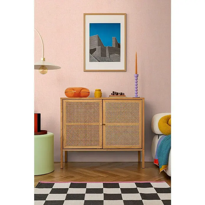 A.S. Création Cosmoliving by Cosmopolitan Vliestapete - Rosa meliert, Uni, 10,05 x 0,53 m - Schrank aus hellem Holz mit Rattangeflecht-Fronten. Dekorative Elemente in Orange und Gelb darauf.