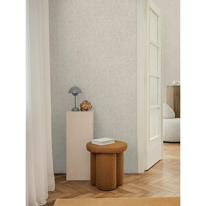 A.S. Création Cosmoliving by Cosmopolitan Vliestapete - Beigegrau, Uni, 10,05 x 0,53 m - Beige Hocker mit Teddyfellbezug, ideal als stilvolle und gemütliche Sitzgelegenheit im Wohnbereich.