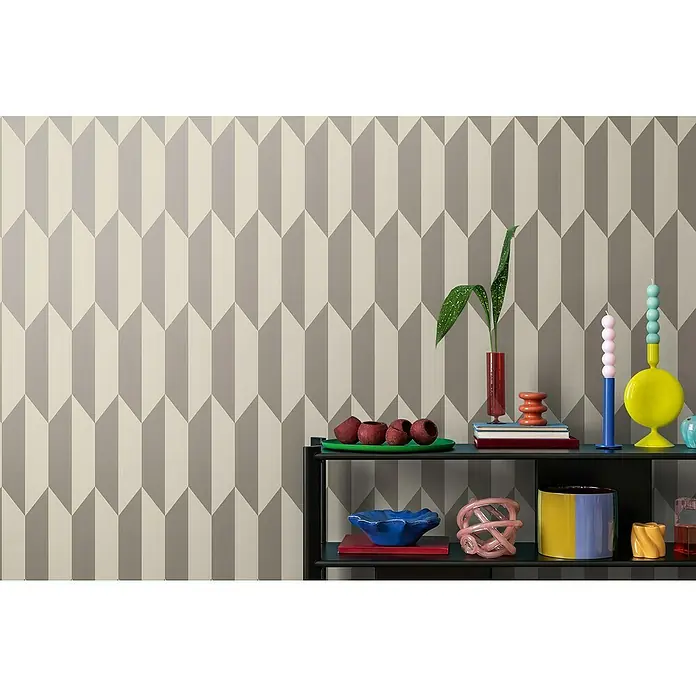 A.S. Création Cosmoliving by Cosmopolitan Vliestapete 3D-Grafik - Creme-Metallic, Grafisch, 10,05 x 0,53 m - Dekorative Tapete mit einem geometrischen Pfeilmuster in Grau und Creme, die eine stilvolle Kulisse für die darauf präsentierten Objekte bildet.