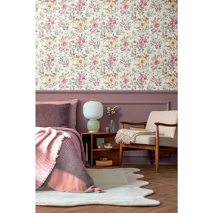 A.S. Création Cosmoliving by Cosmopolitan Vliestapete Blüten - Weiß-Metallic-Grün, Floral, 10,05 x 0,53 m - Zimmer mit gemusterten floralen Tapeten, einem lila Akzent Wand und einem bequemen Sessel neben einem Nachttisch mit Lampe.