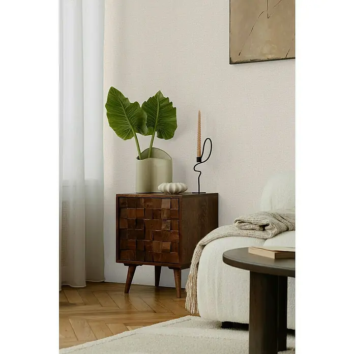 A.S. Création Cosmoliving by Cosmopolitan Vliestapete - Cremebeige, Uni, 10,05 x 0,53 m - Ein stilvolles Interieur mit einem Nachttisch aus Holz mit Blattpflanzen und einer Kerze in einem modernen Raum.