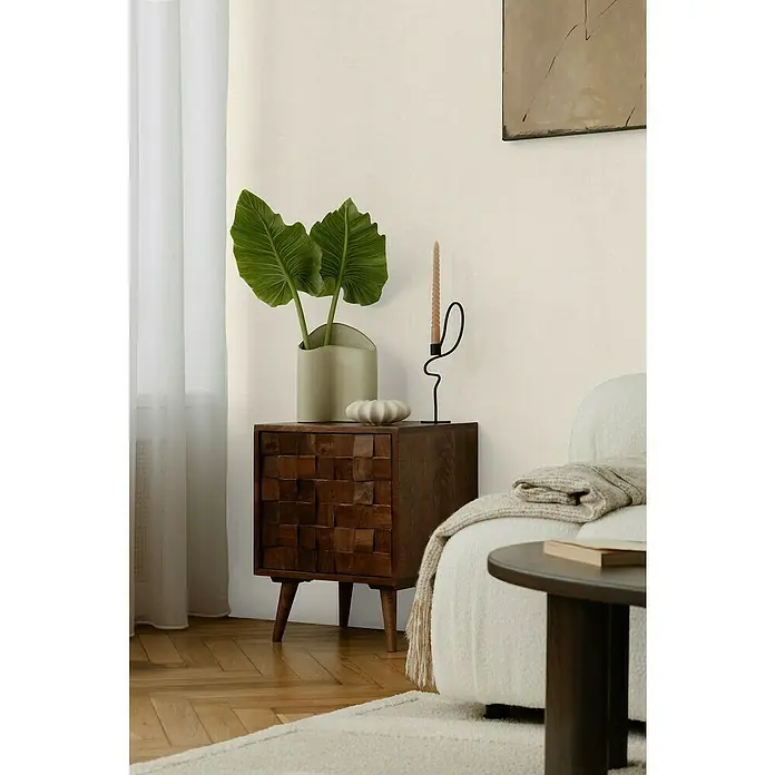 A.S. Création Cosmoliving by Cosmopolitan Vliestapete - Hellbeige, Uni, 10,05 x 0,53 m - Eine Nahaufnahme eines eleganten, dunklen Holzschranks mit einem einzigartigen, blockartigen Design und schlanken Beinen in einem stilvollen Interieur.