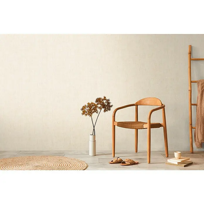 A.S. Création Cosmoliving by Cosmopolitan Vliestapete - Beige, Uni, 10,05 x 0,53 m - Einrichtungsszene mit einem Holzstuhl, einer Leiter und dekorativen Elementen, die eine gemütliche und stilvolle Raumatmosphäre schaffen.