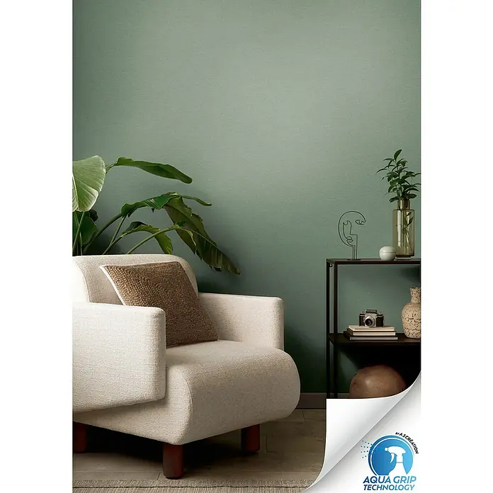 A.S. Création Designdrop Vliestapete - Grün, Uni, 10,05 x 0,53 m - Stilvolles Interieur mit einer mintgrünen Wandtapete, ergänzt durch einen Sessel, Pflanzen und Dekoration, die ein modernes Ambiente schaffen.