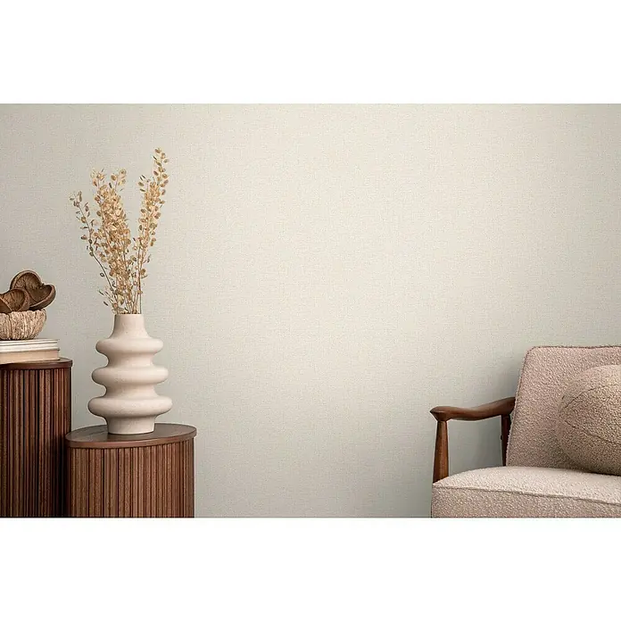 A.S. Création Cosmoliving by Cosmopolitan Vliestapete - Cremebeige, Uni, 10,05 x 0,53 m - Dekoratives Interieur mit einer geriffelten Kommode, einer geschwungenen Vase mit Trockenblumen und einem Vintage-Sessel.