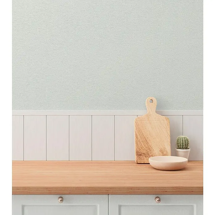 A.S. Création Hygge 3 Vliestapete - Offwhite, Uni, 10,05 x 0,53 m - Nahaufnahme von Schneidebrett, Schale und Kaktus auf einer Küchenarbeitsplatte vor einer hellblauen Wand mit weißen Paneelen.