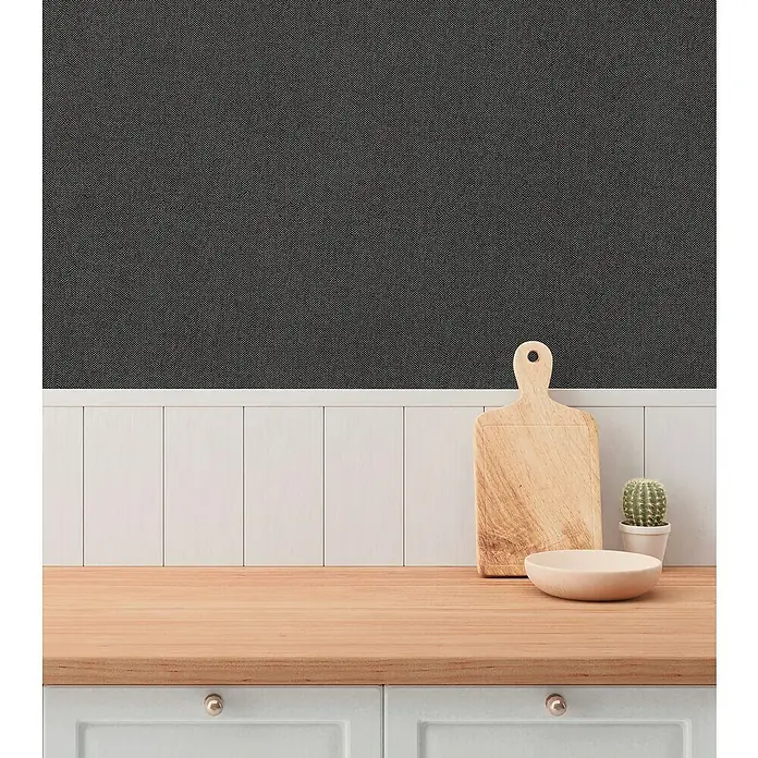 A.S. Création Hygge 3 Vliestapete - Schwarz, Uni, 10,05 x 0,53 m - Nahaufnahme einer hölzernen Schneidebrett- und Schüssel-Anordnung auf einer Küchentheke mit minimalistischem Dekor und grauer Tapete.