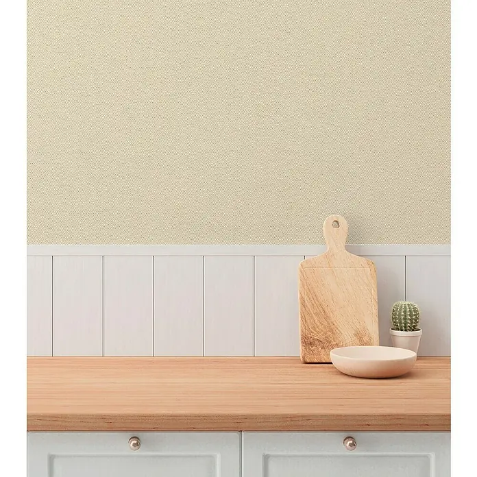 A.S. Création Hygge 3 Vliestapete - Beigecreme, Uni, 10,05 x 0,53 m - Das Foto zeigt eine Küchenarbeitsplatte mit einem Schneidebrett, einer Schale und einem Kaktus vor einer Wand mit Holzpaneelen.