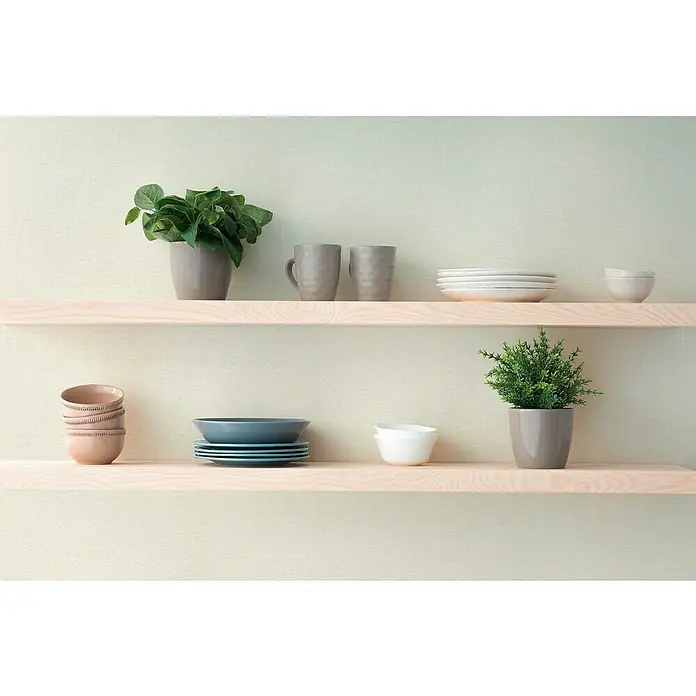 A.S. Création Hygge 3 Vliestapete - Hellgrün, Uni, 10,05 x 0,53 m - Regale mit Pflanzen, Geschirr und Tassen. Die Produkte sind auf zwei Regalen vor einer hellen Wand platziert.