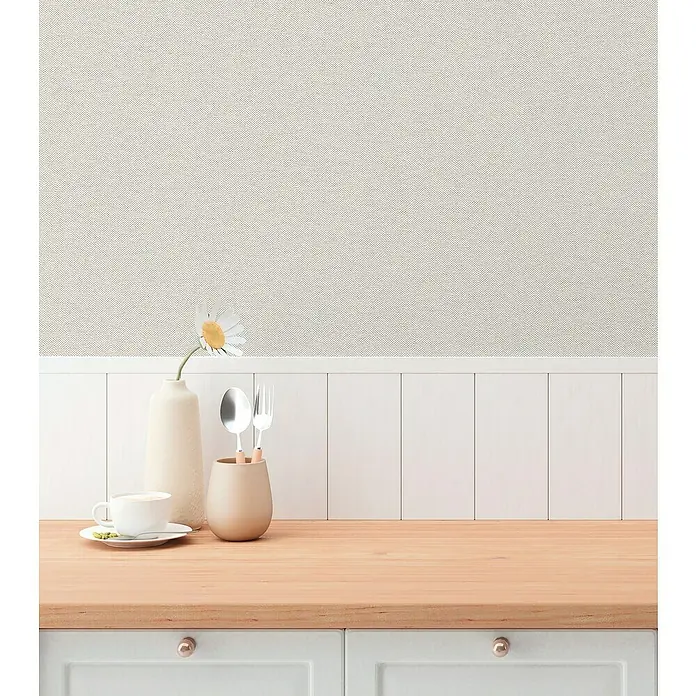 A.S. Création Hygge 3 Vliestapete - Grau, Uni, 10,05 x 0,53 m - Küchentisch-Arrangement mit Geschirr, Tasse, Vase und Blume vor gemusterter Wand und weißer Holzvertäfelung.