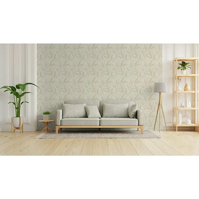 A.S. Création Hygge 3 Vliestapete Blätter - Creme-Grün-Silber, Floral, 10,05 x 0,53 m - Helles Wohnzimmer mit einem Sofa, einer Stehlampe und einem Bücherregal. Das Zimmer ist mit einer dezenten Tapete geschmückt.