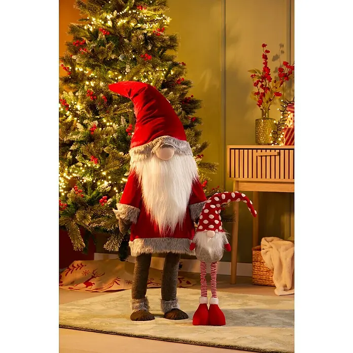 Figura decorativa Gnomo Esben - L x An x Al: 40 x 28 x 125 cm, Textil, Elfos de Navidad - Dos gnomos navideños festivos se alzan frente a un árbol de Navidad decorado y una cómoda, transmitiendo alegría navideña.
