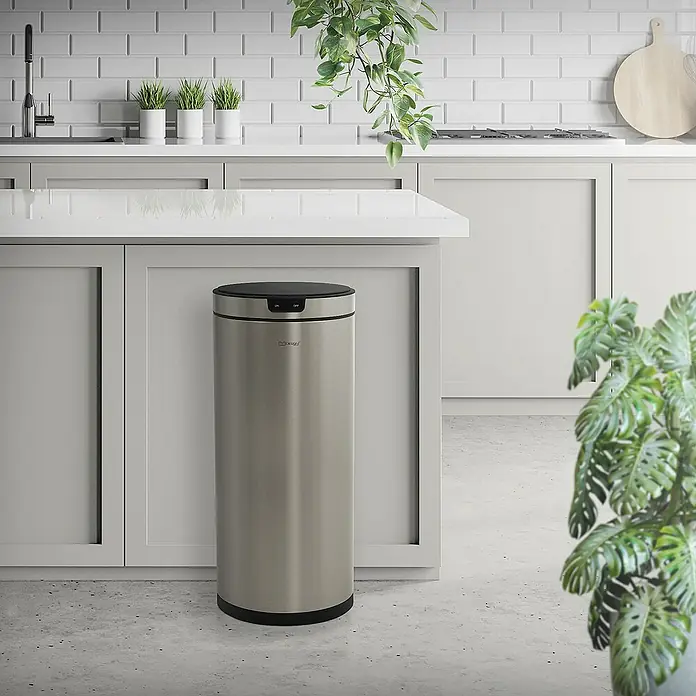 ML-Design Sensormülleimer 40L rund Edelstahl Abfalleimer berührungslos, Klemmring für Müllbeutel - 40 l, Stahl, Silber - Ein moderner, silberfarbener Mülleimer aus Edelstahl mit schwarzem Deckel steht in einer hellen Küche.