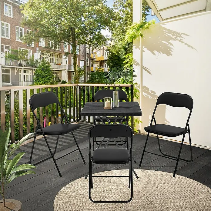 ECD Germany Gartenstuhl 4er Set Gartenstuhl faltbar Schwarz Stahl Wetterfest UV-beständig -  - Balkonansicht mit einem schwarzen Gartentischset mit vier Klappstühlen auf einem runden Teppich mit Blick auf die Stadt.