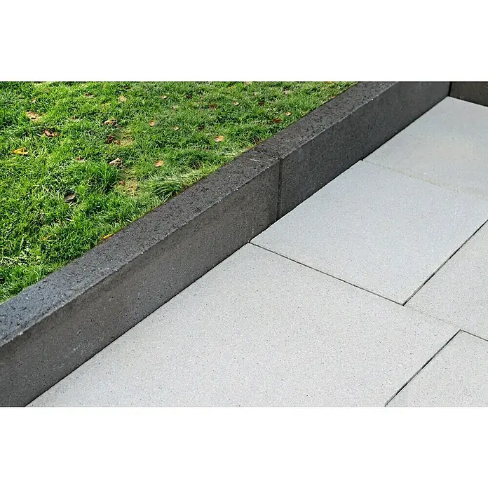 Christoph Randstein - 100 x 7 x 17 cm, Anthrazit, Beton - Detailaufnahme von Betonpflastersteinen und einer dunklen Betonbordüre, die einen sauberen Übergang zu einem grünen Rasen schafft.