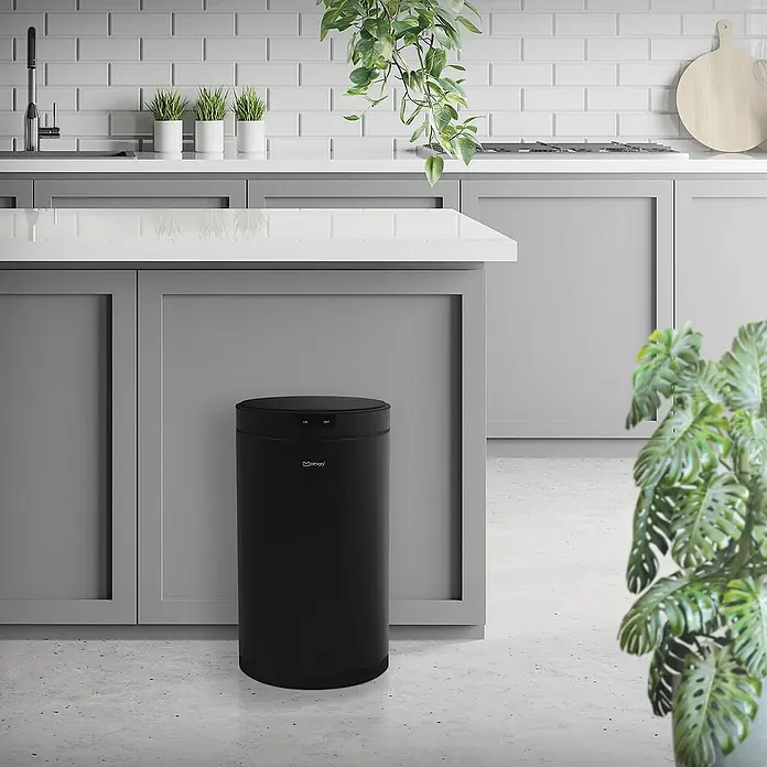 ML-Design Sensormülleimer 30L rund aus Stahl Abfalleimer berührungslos, Klemmring für Müllbeutel - 30 l, Stahl, Schwarz - Ein schwarzer, runder Mincael Automatik-Mülleimer steht in einer modernen Küche mit grauen Schränken und weißen Arbeitsplatten.