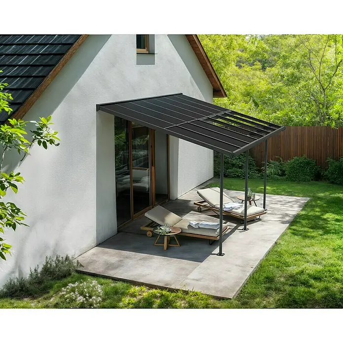 Palram – Canopia Terrassenüberdachung Sierra Cabrio - B x T: 430 x 300 cm, Anthrazitgrau, Polycarbonat, Grau - Terrassenüberdachung aus schwarzem Metall mit Liegestühlen auf einer Betonterrasse. Das Vordach bietet Schatten und Schutz.